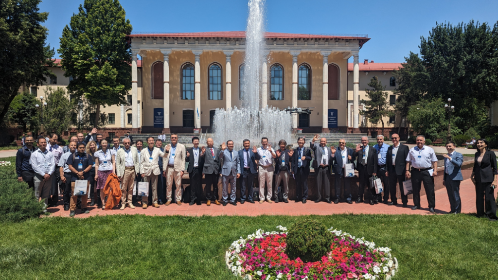 Group of Participants of ICTEA 2024 lined up in front of a Building and Fountain