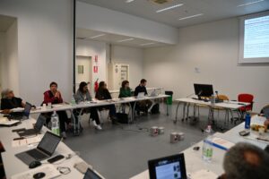 th BioMembrOS team in the conference room, sitting at tables in U formation anmd listening to a presentation