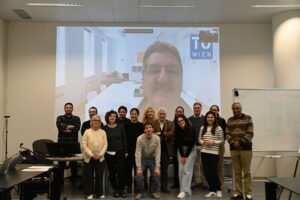 The BioMembrOS Team in front of a wall with the Zoom interface of Michael Harasek projected on to it