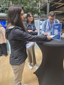 Monica Faria and two others standing around a round table with a black cloth
