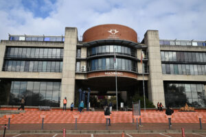 The Entrance to the University of Johannesburg. From the path with red bricks, some stairs lead up to the building, that is a combination of red and grey bricks and a has huge glass windows