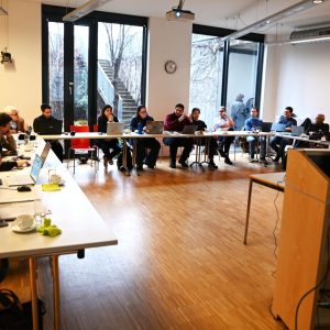 Overview of the meeting room with a U shaped table formation for our Consortium Meeting at Medizinische Universität Wien. Our members already sitting and listening to a presentation